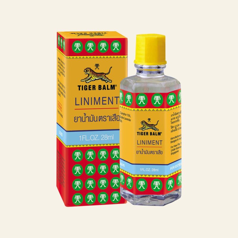 Tiger Balm Liniment 28 ml bottle and box on a warm cream background