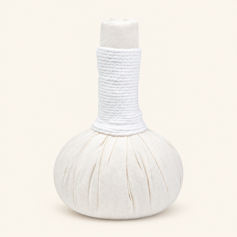 One Poompuksa 200 g Thai herbal compress ball on a plain warm ivory background