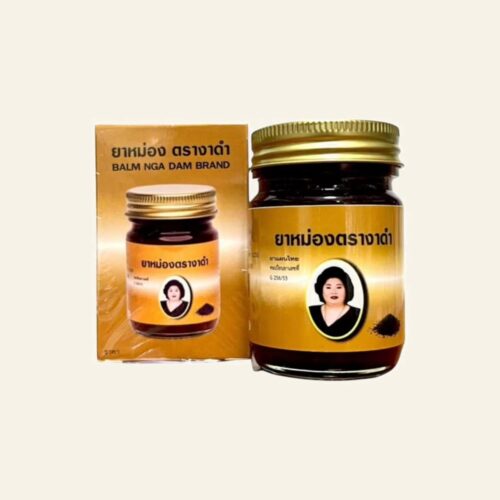 Nga Dam black sesame Thai massage balm 50 g jar and box on a warm cream background